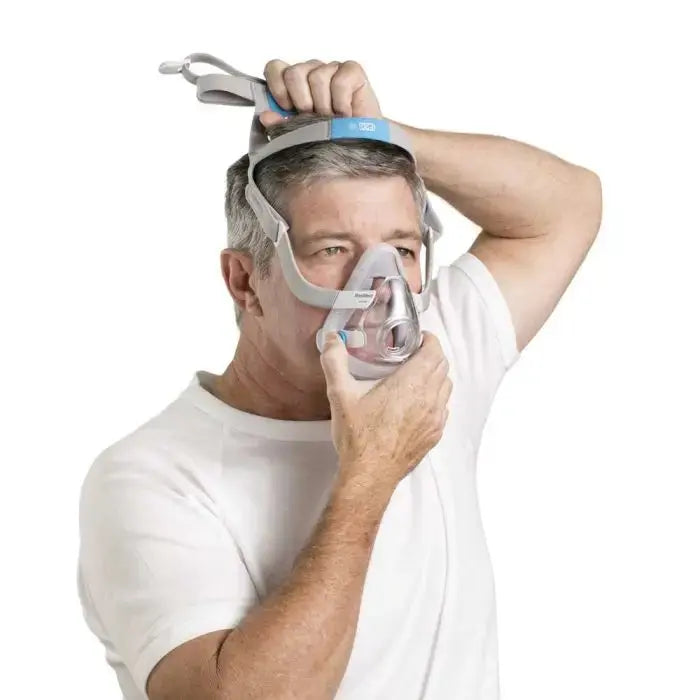 Man wearing a CPAP mask on a white background