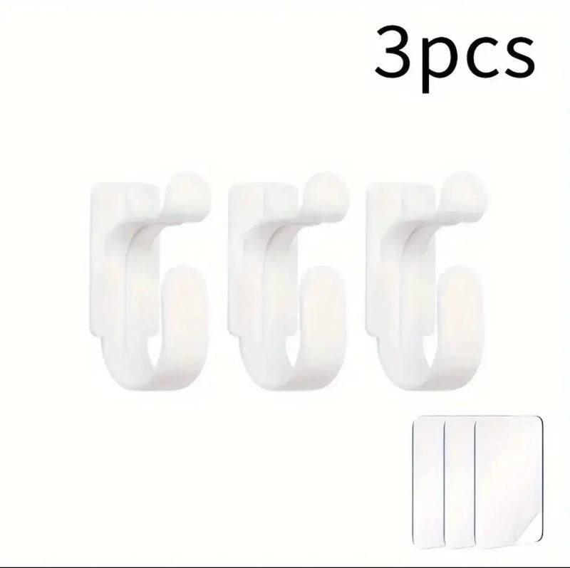 Three white hooks with a small adhesive strip on a white background